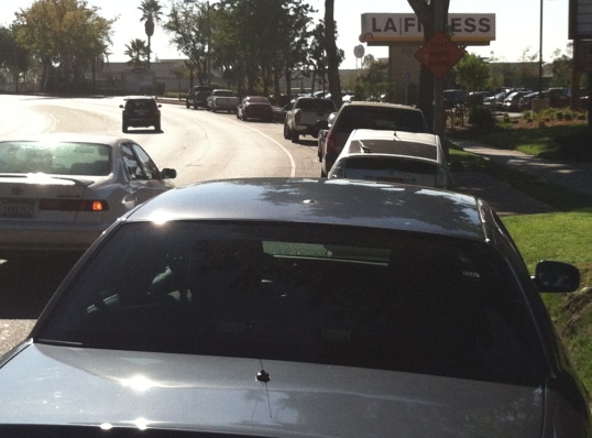Parked cars (mostly for the fitness center on the right) force bicycles into the fast-moving traffic lane. Pasadena DOT could make this a no parking zone and have plenty of room for buffered or protected bike lanes here. 