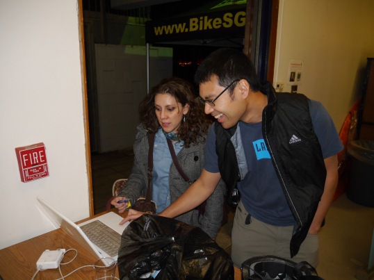 Daniella Alcedo (L) of the Pomona Valley Bicycle Coalition, and Cuong Phu Trinh look over BikeSGV's plans at the open house. 